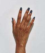 Hand with dark skin tone wearing JINsoon Abyss nail polish against a white background