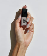 Hand with light skin tone wearing JINsoon Auspicious nail polish against a white background