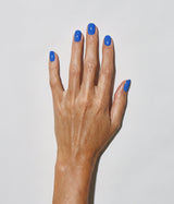 Hand with medium skin tone wearing JINsoon Cool Blue nail polish against a white background