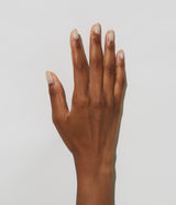 Hand with dark skin tone wearing JINsoon Dew nail polish against a white background