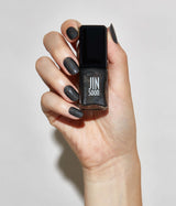 Hand with light skin tone wearing JINsoon Mica nail polish against a white background