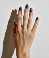 Hand with medium skin tone wearing JINsoon Mica nail polish against a white background