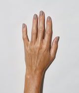 Hand with medium skin tone wearing JINsoon Milieu nail polish against a white background