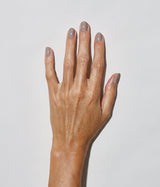 Hand with medium skin tone wearing JINsoon Milieu nail polish against a white background