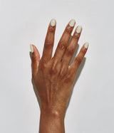 Hand with dark skin tone wearing JINsoon Piedra nail polish against a white background
