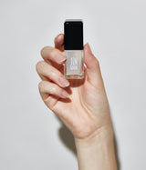 Hand with light skin tone wearing JINsoon Power Coat base coat against a white background