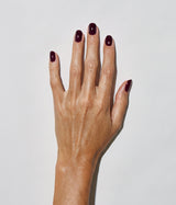 Hand with medium skin tone wearing JINsoon Risque nail polish against a white background