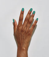 Hand with dark skin tone wearing JINsoon Scuba nail polish against a white background