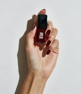 Hand with light skin tone wearing JINsoon Theda nail polish against a white background