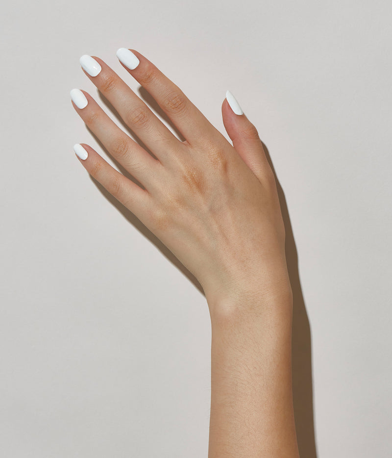 Hand model with JINsoon Absolute White against a white background (pale skin tone).