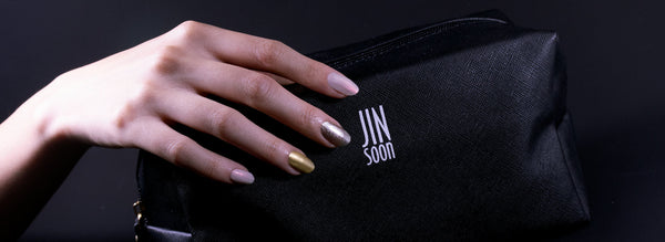 Metallic colored Nail polish on hand with JINsoon makeup bag
