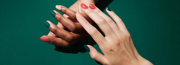 two hands gently touching each other with different manicures