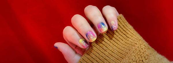 Holiday nail design in front of a red wall