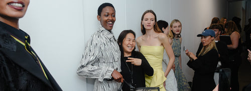 Models and team smiling backstage at New York Fashion Week