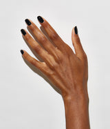 Hand with dark skin tone wearing JINsoon Absolute Black nail polish against a white background