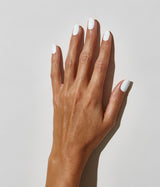 Hand with dark skin tone wearing JINsoon Absolute White nail polish against a white background