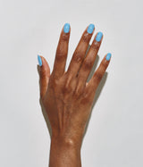 A close-up of a hand with neatly manicured nails painted in a light sky blue color