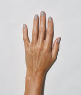 Hand with medium skin tone wearing JINsoon Auspicious nail polish against a white background