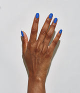 Hand with dark skin tone wearing JINsoon Cool Blue nail polish against a white background