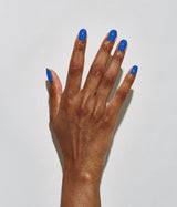 Hand with dark skin tone wearing JINsoon Cool Blue nail polish against a white background