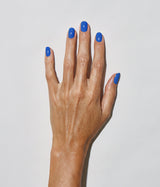 Hand with medium skin tone wearing JINsoon Cool Blue nail polish against a white background