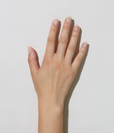 Hand with light skin tone wearing JINsoon Dew nail polish against a white background