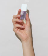 Hand with light skin tone wearing JINsoon HyperGloss top coat against a white background