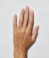 Hand with medium skin tone wearing JINsoon HyperGloss top coat against a white background