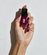 Hand with fair skin tone wearing JINsoon Heroine nail polish against a white background