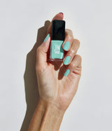 Hand with fair skin tone wearing JINsoon Keppel nail polish against a white background