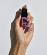 Hand with light skin tone wearing JINsoon Lavanda nail polish against a white background