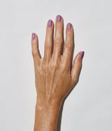 Hand with medium skin tone wearing JINsoon Lavanda nail polish against a white background