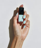 Hand with fair skin tone wearing JINsoon Peace nail polish against a white background