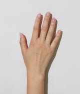 Hand with light skin tone wearing JINsoon Pixie nail polish against a white background