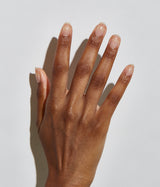 Hand with dark skin tone wearing JINsoon Power Coat base coat against a white background