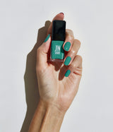 Hand with fair skin tone wearing JINsoon Scuba nail polish against a white background