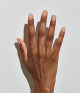 Hand with dark skin tone wearing JINsoon Top Gloss top coat against a white background