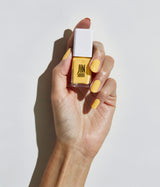 Hand with fair skin tone wearing JINsoon Tweety nail polish against a white background
