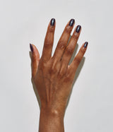 Hand with dark skin tone wearing JINsoon Uma nail polish against a white background